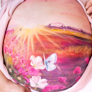Bemalung auf Schwangerschaftsbauch mit einer Blumenwiese