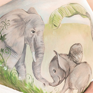 Bemalung auf Schwangerschaftsbauch mit einer Elefantenfamilie