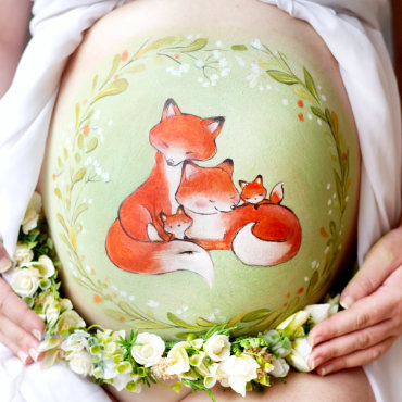 Bemalung auf Schwangerschaftsbauch mit einer Fuchsfamilie