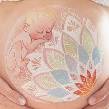 Bemalung auf Schwangerschaftsbauch mit einem Kind  an einem Mandala