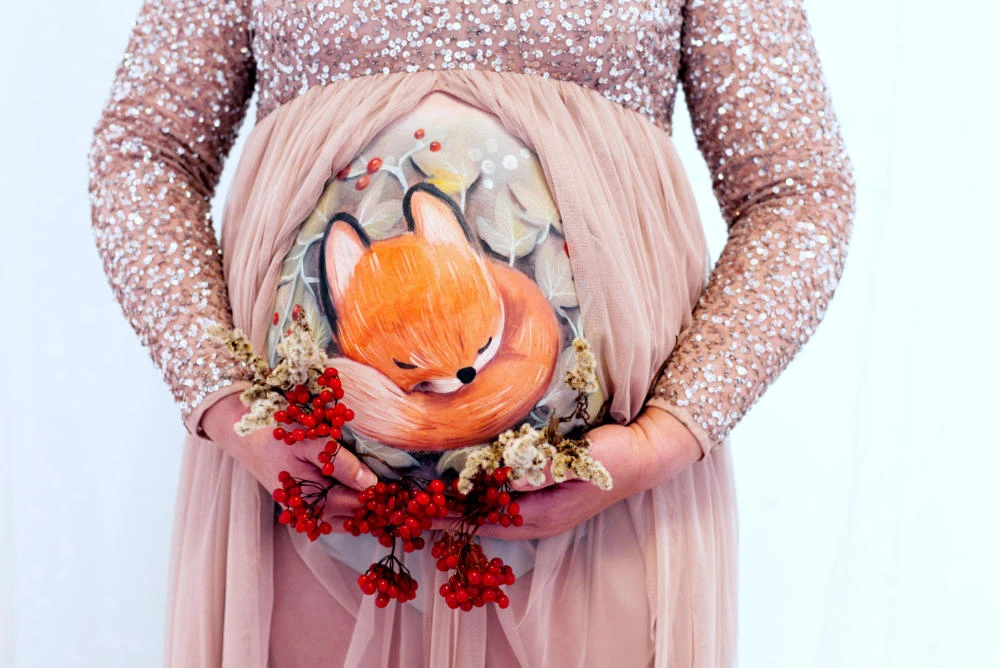 Babybauchbemalung mit schlafendem Fuchs, Beeren und Trockenblumen – winterliches Motiv von cy-DESIGN