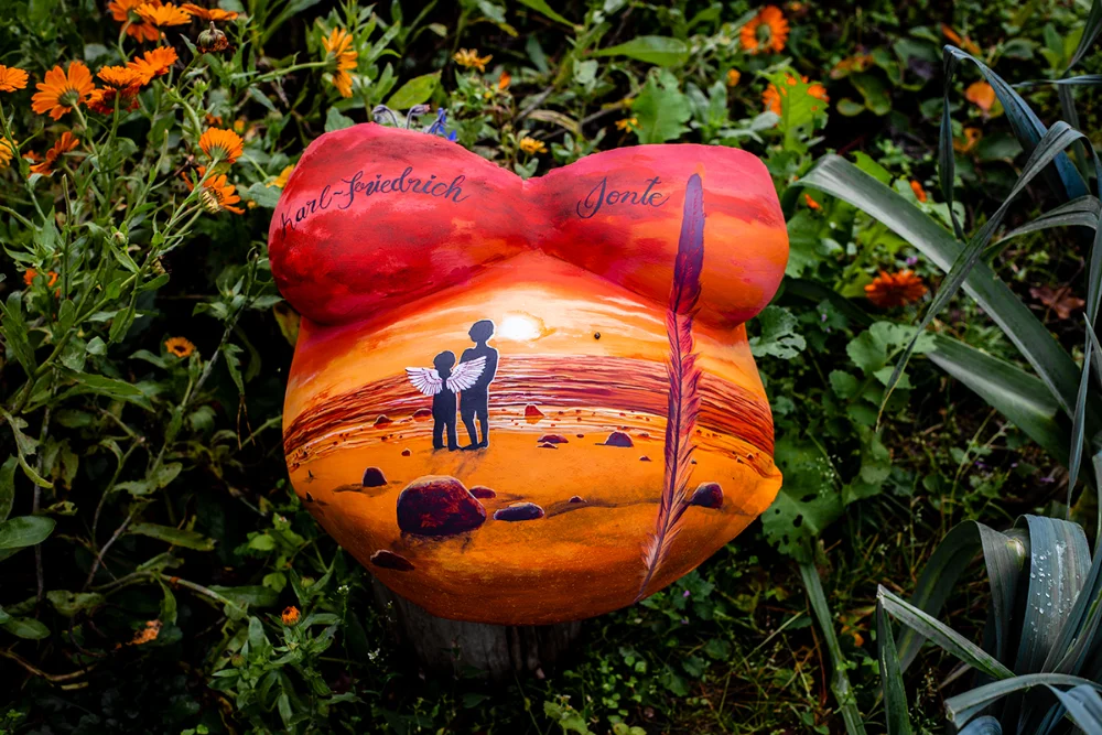 Künstlerisch bemalter Gipsabdruck mit Sonnenuntergang, Kindern am Strand und Namen – individuelle Erinnerung an Schwangerschaft

