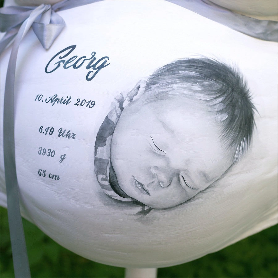 Detailaufnahme eines bemalten Gipsbauchs mit Babygesicht von Georg, Geburtsdaten und Schleife – monochromes, emotionales Design