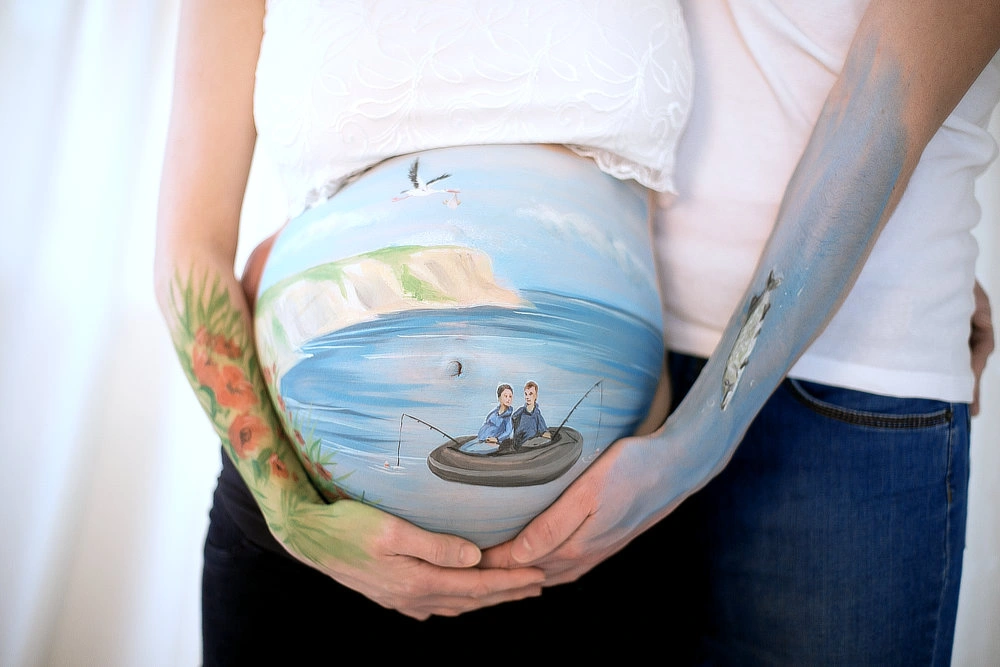 Bemalung auf Schwangerschaftsbauch Angelausflug an der Ostsee
