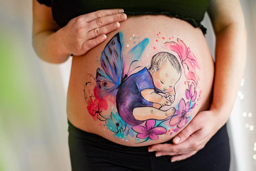 Bemalung auf Schwangerschaftsbauch Baby mit Schmetterlingsflügeln
