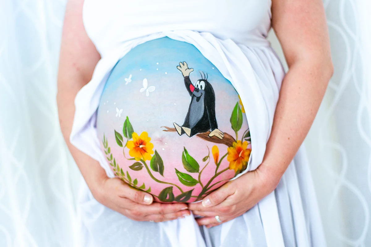 Bemalung auf Schwangerschaftsbauch mit dem Maulwurf und Blumen