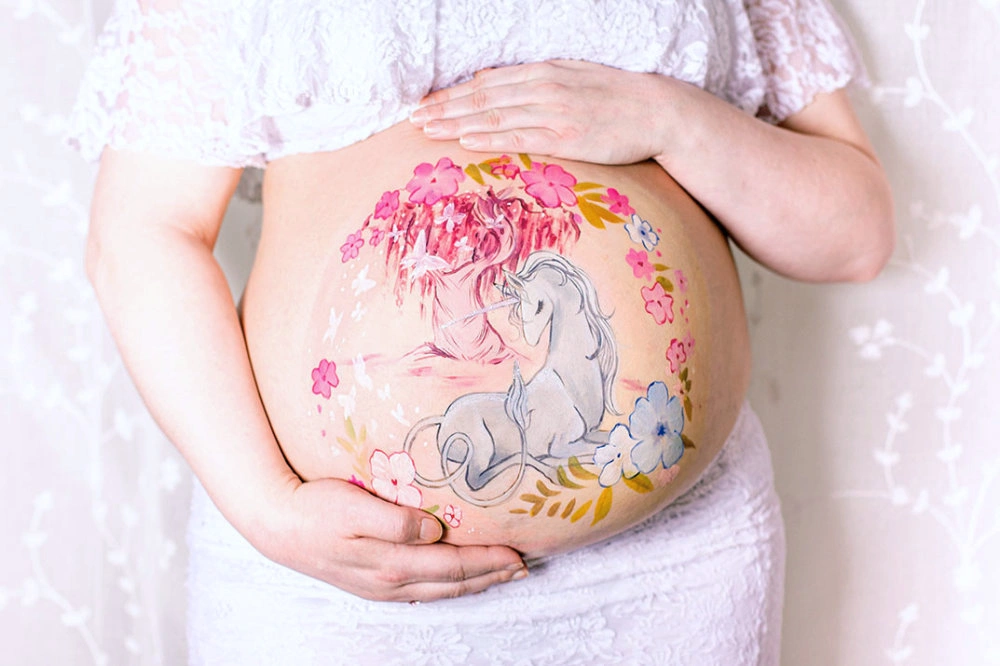 Bemalung auf Schwangerschaftsbauch mit einem Einhorn
