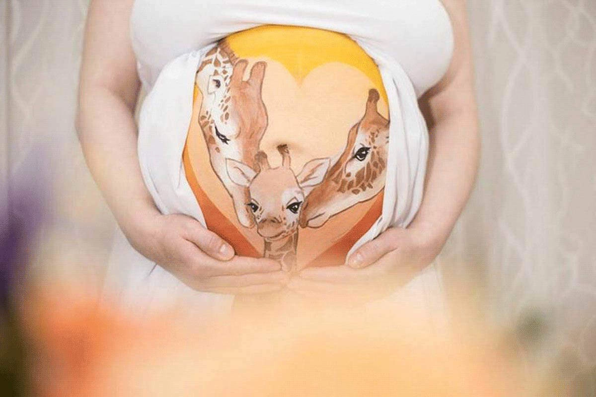 Bemalung auf Schwangerschaftsbauch mit einer Giraffenfamilie

