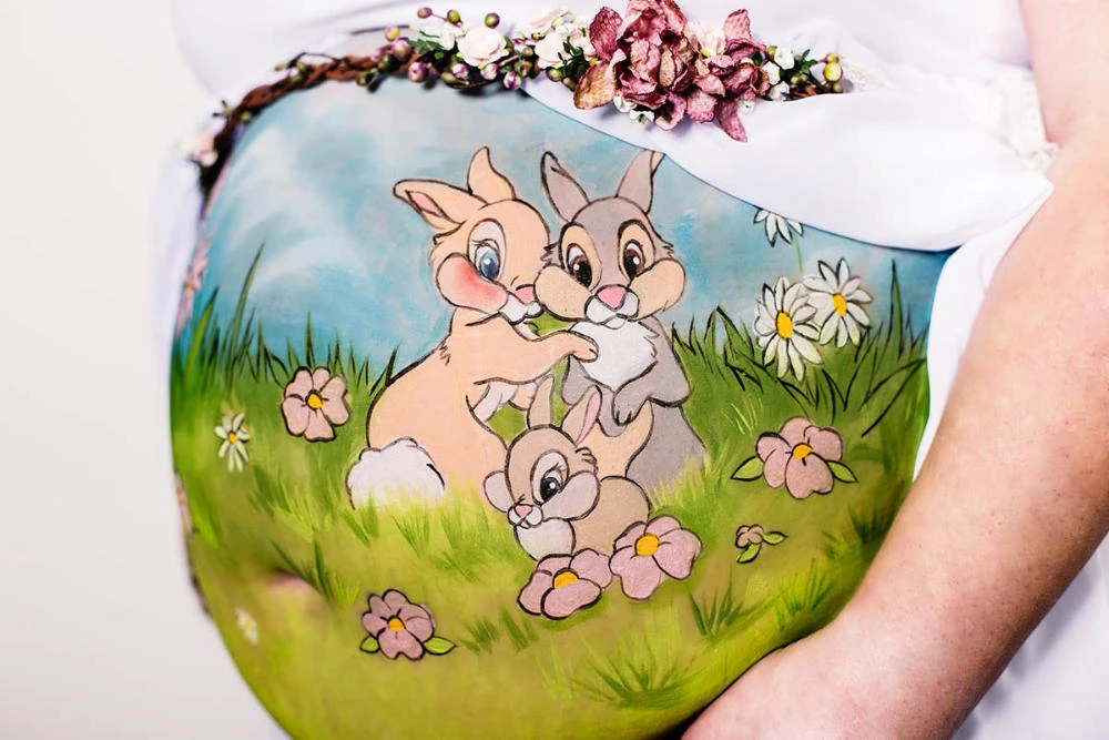 Bemalung auf Schwangerschaftsbauch mit einer Hasenfamilie
