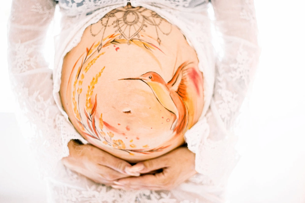 Bemalung auf Schwangerschaftsbauch mit einem Kolibri
