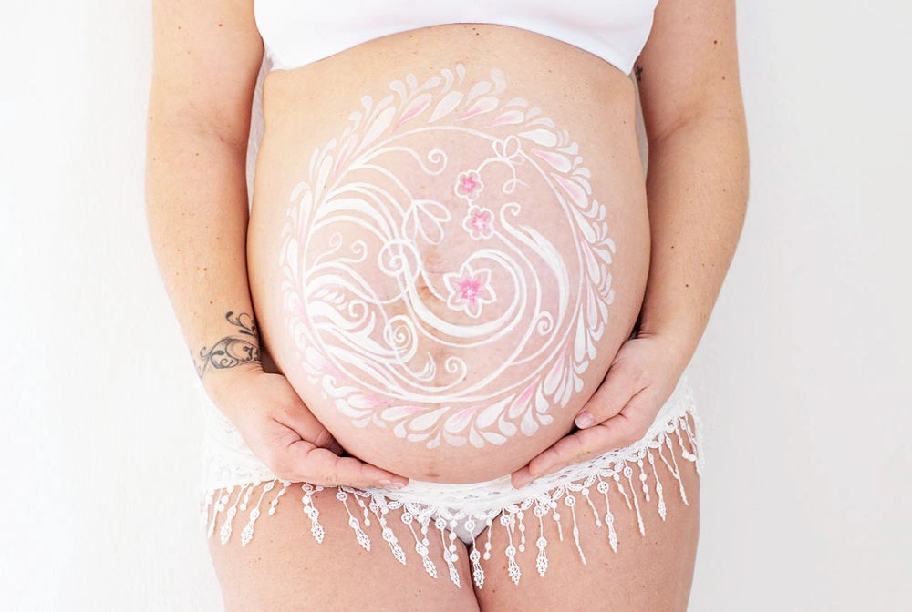 Bemalung auf Schwangerschaftsbauch mit einem Mandala
