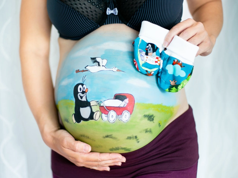 Bemalung auf Schwangerschaftsbauch mit einer der dem Maulwurf und Kinderwagen
