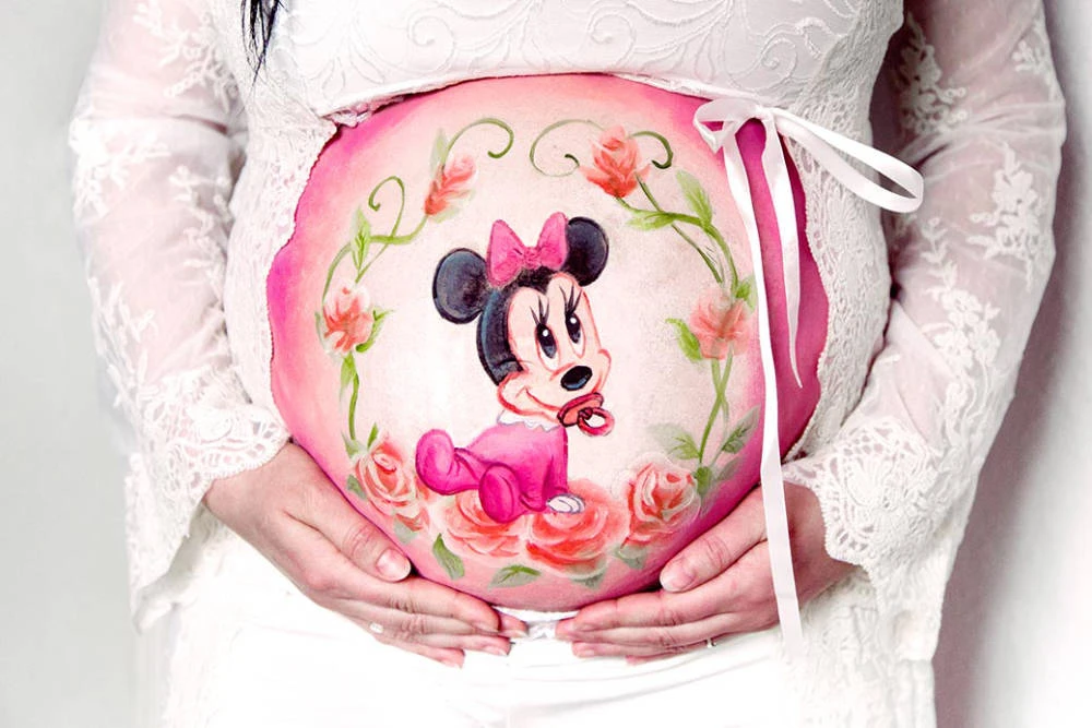 Bemalung auf Schwangerschaftsbauch mit einer Hasenfamilie
