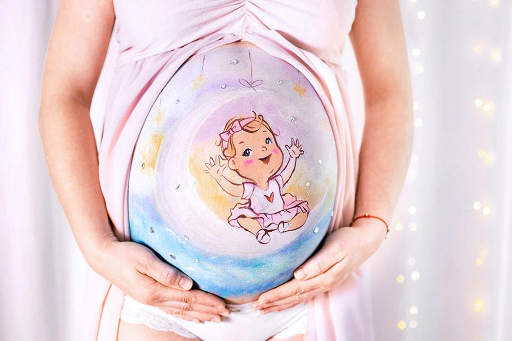Bemalung auf Schwangerschaftsbauch mit einem Mond und einem Baby

