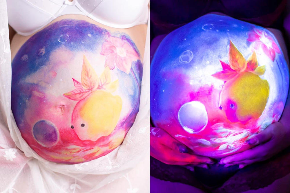 Bemalung auf Schwangerschaftsbauch mit einer Fantasiefigur mit UV-Farbe

