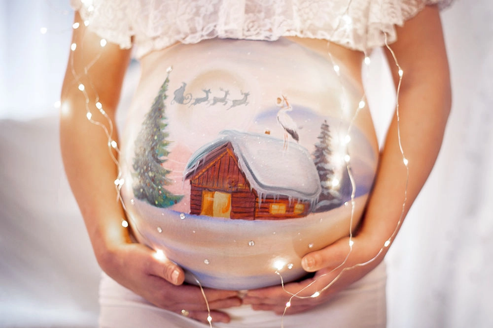 Bemalung auf Schwangerschaftsbauch mit einem Weihnachtsmotiv
